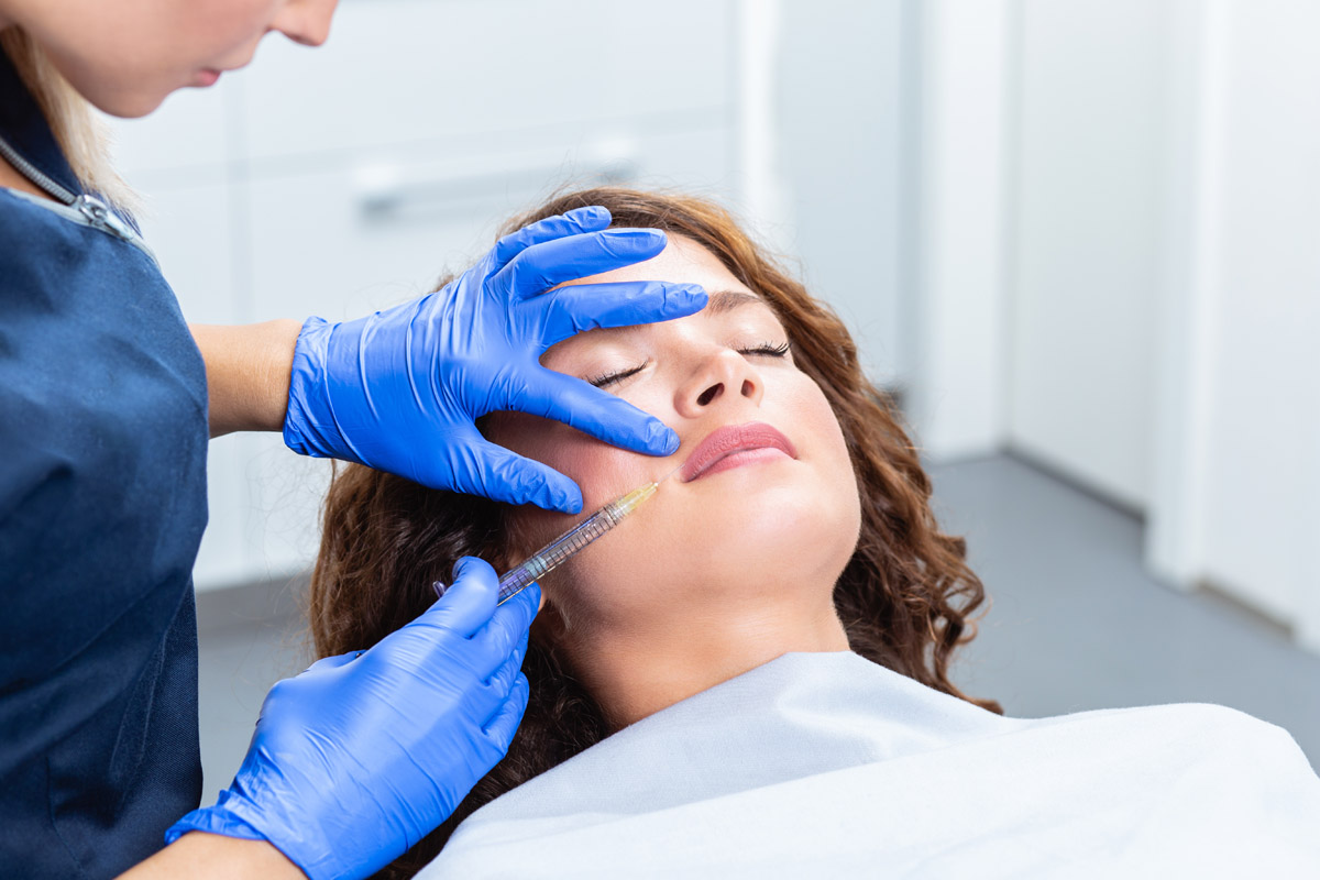 Attractive young woman is getting a rejuvenating facial injectio